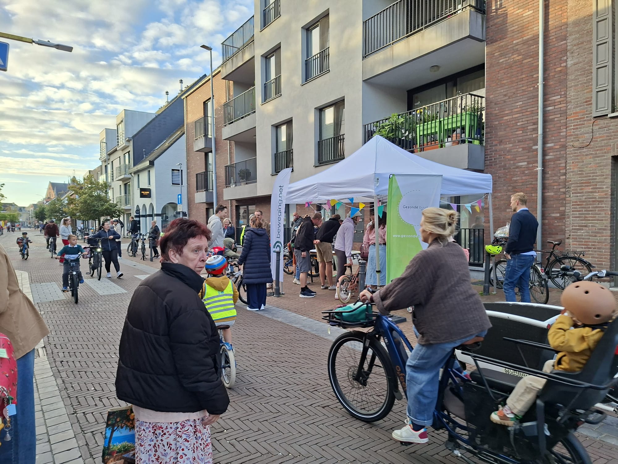 Straatbeeld in de buurt van een school met verschillende fietsers en wandelaars.